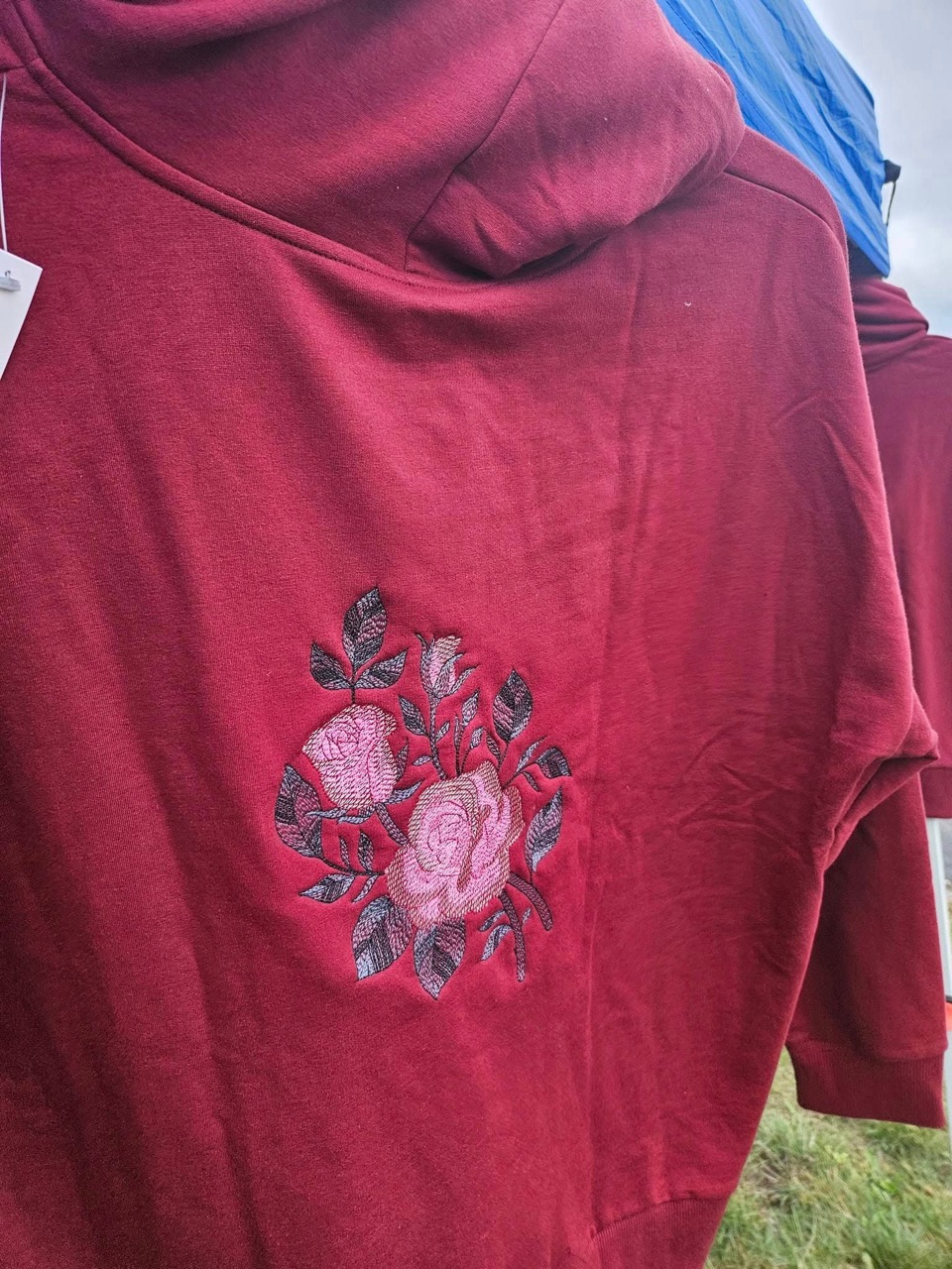 Burgundy t-shirt with a hand-embroidered pink rose design
