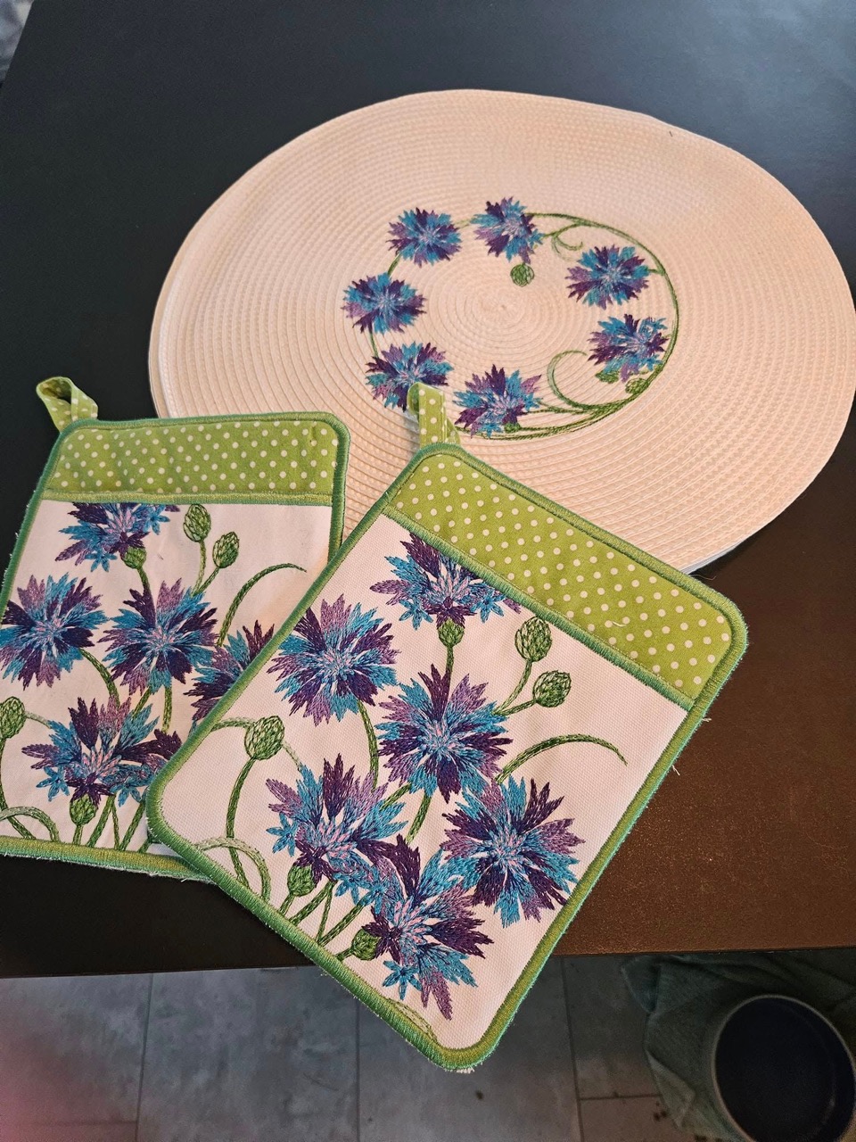 A floral cornflower-embroidered potholder and trivet set